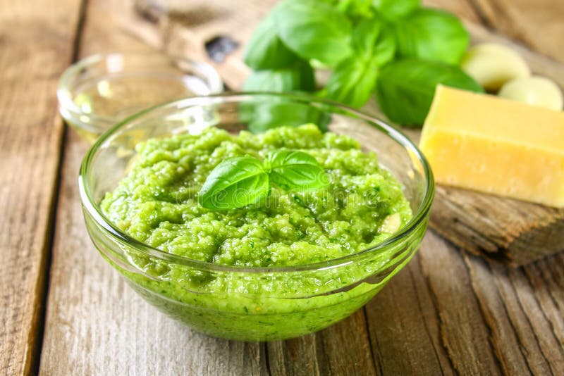 Salsa casalinga di Pesto ingredienti Formaggio, aglio, basilico, pinoli, olio d'oliva su una vecchia tavola di legno immagine stock libera da diritti Salsa casalinga di Pesto ingredienti Formaggio, aglio, basilico, pinoli, olio d'oliva su una vecchia tavola di legno immagine stock libera da diritti