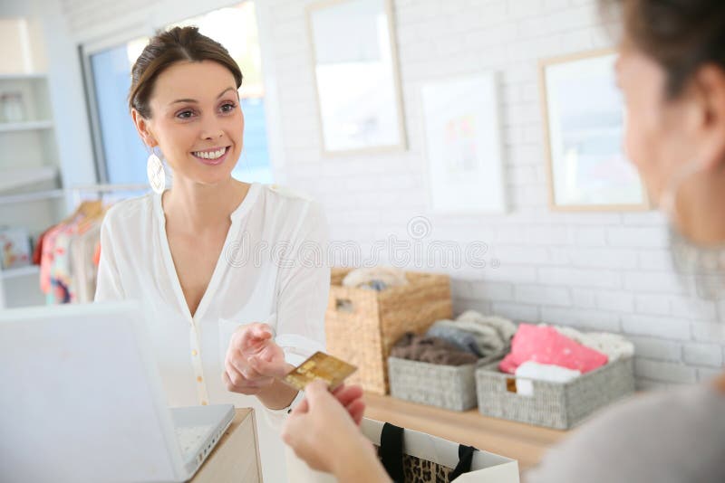 Salseswoman in the clothing shop cashing in the purchase of her customer