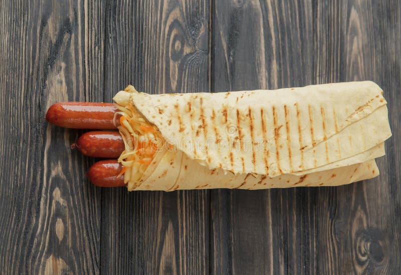 Salsiccie piccanti in pane della pita su fondo di legno Foto con lo spazio della copia immagine stock Salsiccie piccanti in pane della pita su fondo di legno Foto con lo spazio della copia immagine stock