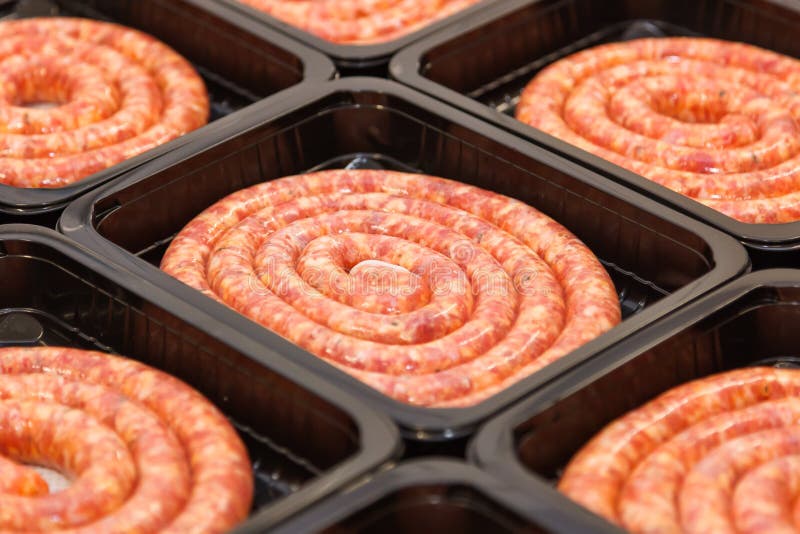 Rolled raw meat sausages in packing box, meat production. Rolled raw meat sausages in packing box, meat production