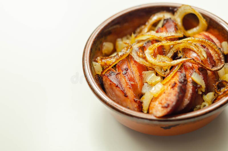 Salsicha alemã tradicionalmente torrada com cebola servida numa tigela de cerâmica foto de stock royalty free