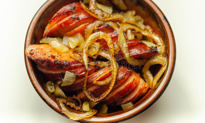 Salsicha alemã tradicionalmente torrada com cebola servida numa tigela de cerâmica imagem de stock