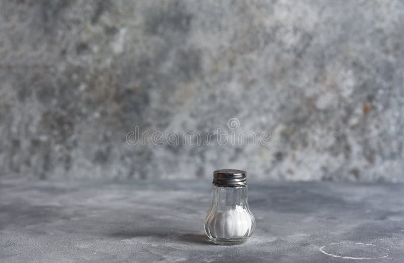 Salt in a Glass Jar on a Concrete Background. Salt Shaker Stock Photo