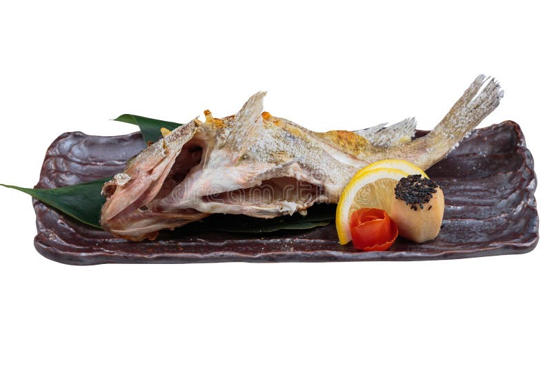 Salt-grillade Snapper Shioyaki tjänade som med den skivade citronen och tomaten på stenplattan arkivfoton Salt-grillade Snapper Shioyaki tjänade som med den skivade citronen och tomaten på stenplattan arkivfoton