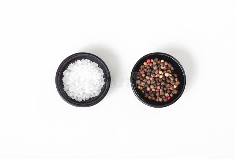 Salt and pepper in black bowl on white background