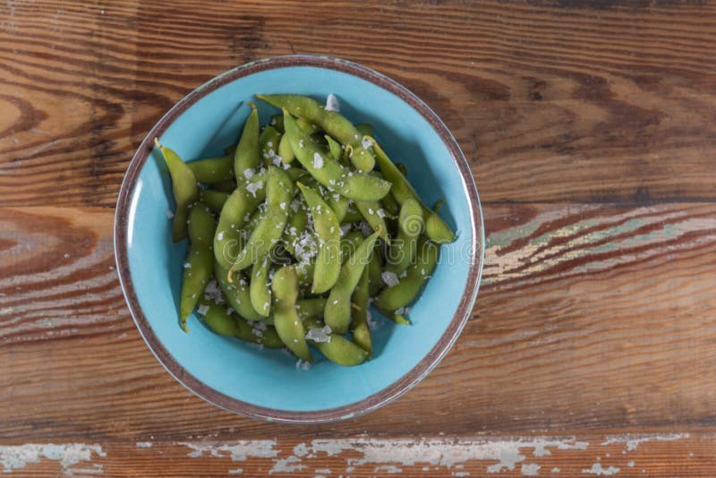 Saltade Edamame i blå bunke arkivbilder