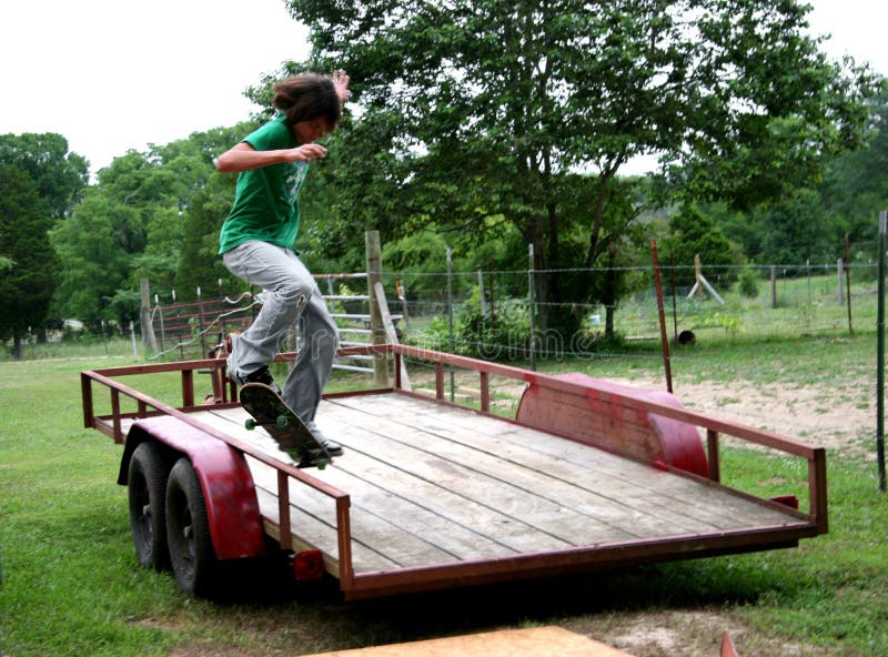Teen male skateboarder jumping onto trailer rail. Shot with Canon 20D. Teen male skateboarder jumping onto trailer rail. Shot with Canon 20D.