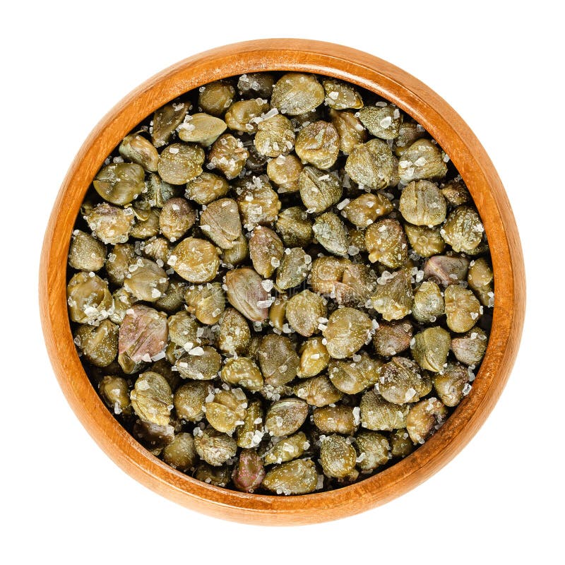 Salted capers in wooden bowl over white royalty free stock image