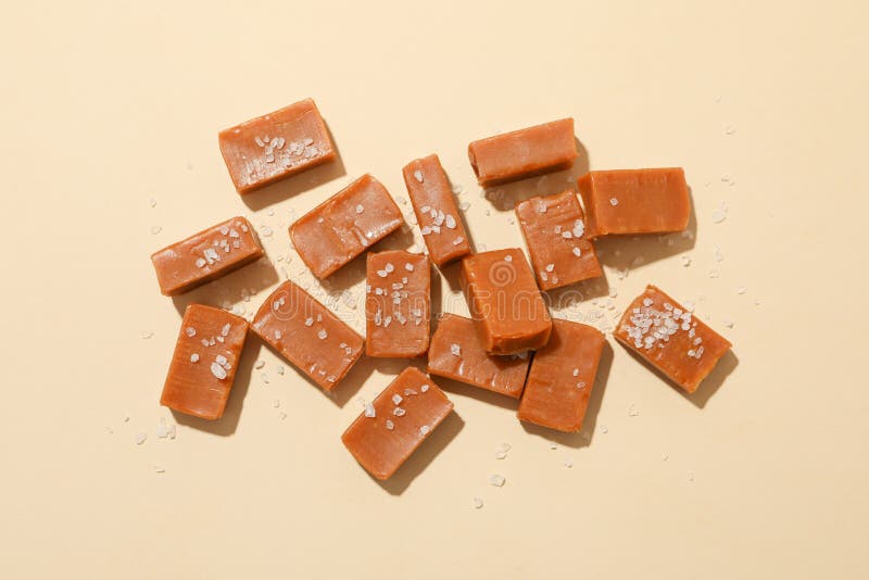 Salted caramel candies on beige background