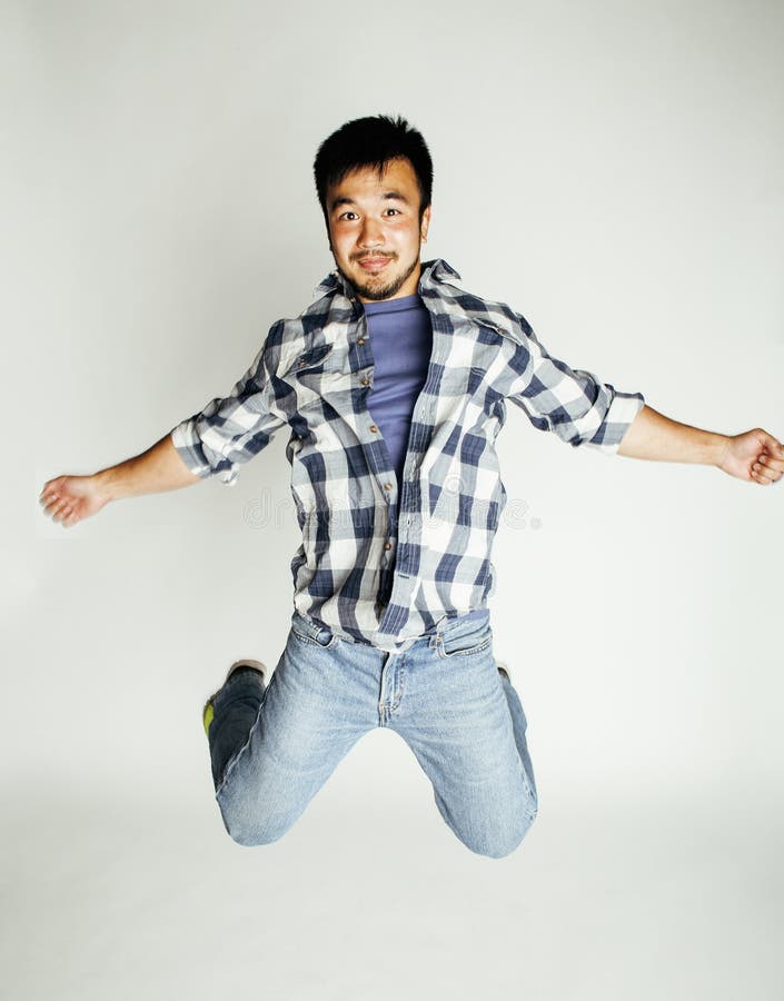 Salto asiático bonito novo do homem alegre contra o fundo branco, conceito dos povos do estilo de vida foto de stock royalty free Salto asiático bonito novo do homem alegre contra o fundo branco, conceito dos povos do estilo de vida foto de stock royalty free