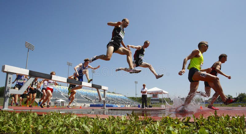 Salto de água dos homens da trilha da corrida de obstáculos imagem de stock Salto de água dos homens da trilha da corrida de obstáculos imagem de stock