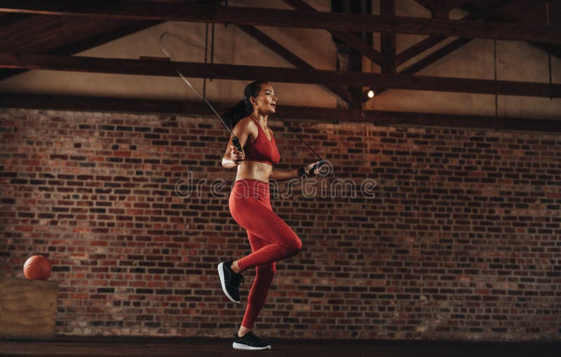 Salto della corda sano della donna alla palestra fotografia stock libera da diritti Salto della corda sano della donna alla palestra fotografia stock libera da diritti