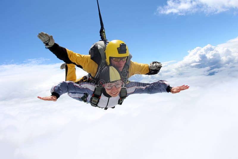Salto en tándem El saltar en caída libre en el cielo azul foto de archivo Salto en tándem El saltar en caída libre en el cielo azul foto de archivo