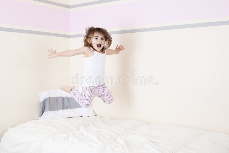 Adorable preschooler jumping on the bed. Room for your text. Adorable preschooler jumping on the bed. Room for your text.