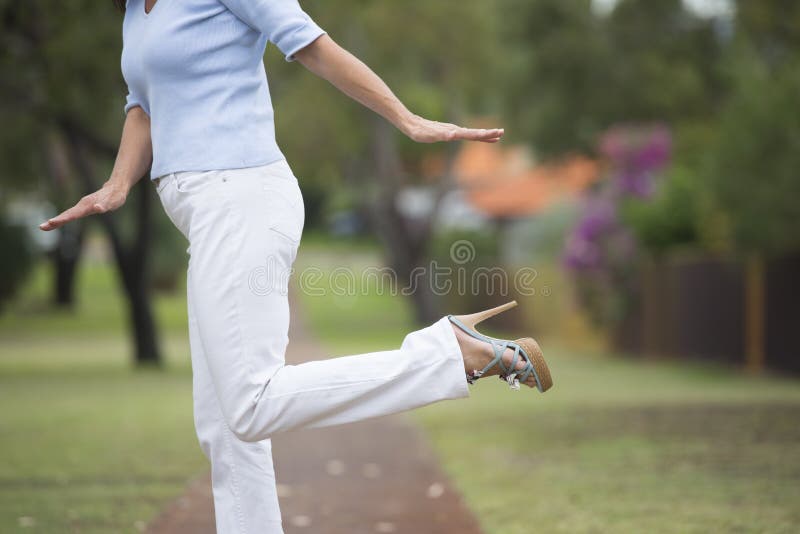 Saltos altos que equilibram a mulher exterior foto de stock Saltos altos que equilibram a mulher exterior foto de stock