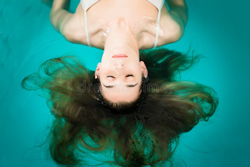 Salud - mujer joven que flota en balneario