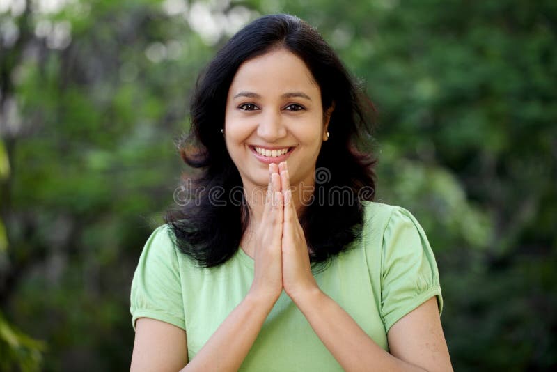 Salutation heureuse de jeune femme avec Namasthe