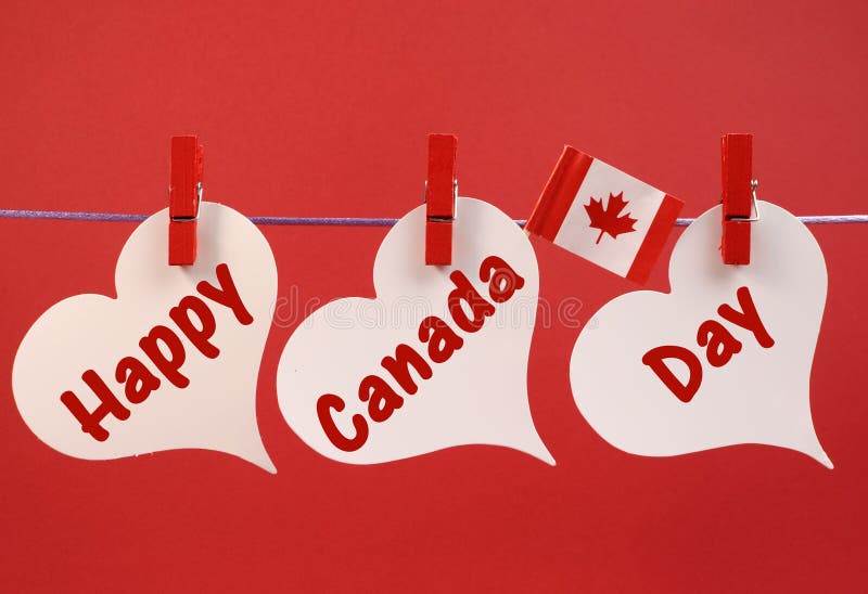 Salutation heureuse de message de jour de Canada avec le drapeau canadien de feuille d'érable pendant des chevilles sur une ligne