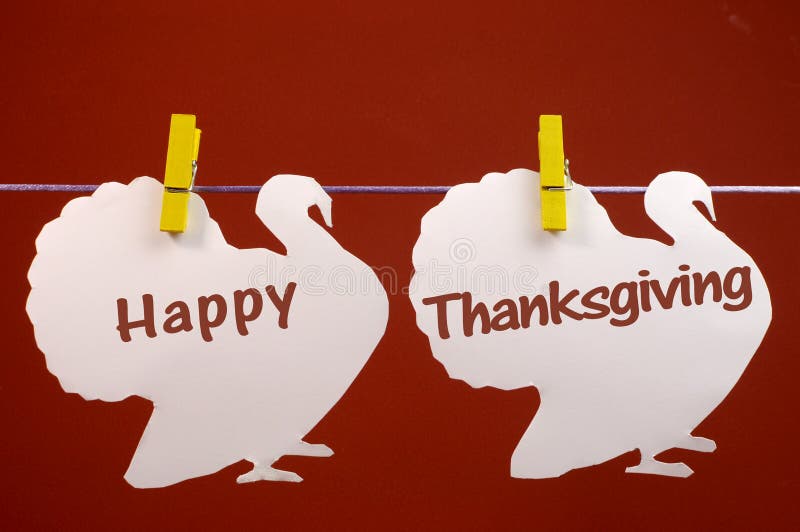 Salutation heureuse de message de thanksgiving écrite à travers les dindes blanches pendant des chevilles sur une ligne