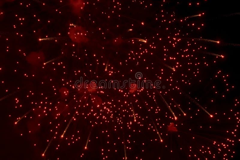 Salute. Bright, red splashes of fireworks in the dark sky. Night fireworks.