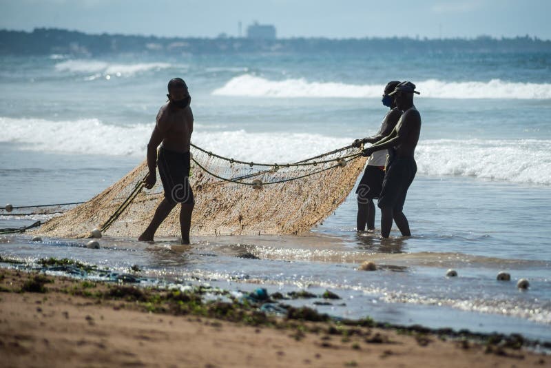 Fishermen Pulling the Fishing Net from the Sea with Fish Inside