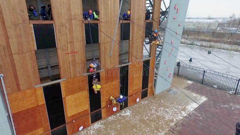 Salvadores del lanzamiento de Quadrocopter en maniquí uniforme de la elevación Pared del entrenamiento Cámara lenta