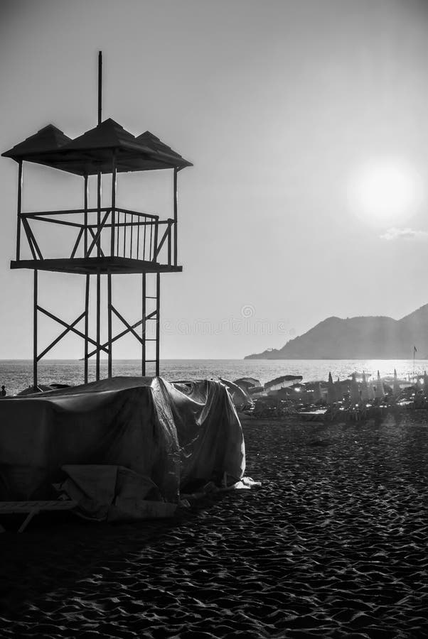 Salvi la spiaggia sabbiosa dell'oceano del mare della torre del bagnino al tramonto nella sera fotografia stock libera da diritti Salvi la spiaggia sabbiosa dell'oceano del mare della torre del bagnino al tramonto nella sera fotografia stock libera da diritti