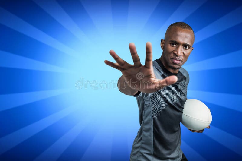 Samengesteld beeld van close-upportret die van sportman terwijl status met rugbybal gesturing stock foto's Samengesteld beeld van close-upportret die van sportman terwijl status met rugbybal gesturing stock foto's