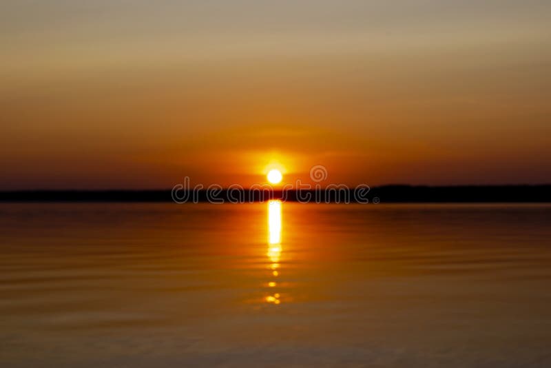 Samenvatting vage achtergrond met het landschap van het de zomermeer met gouden zonsopgang Het wordt gefotografeerd in de vroege