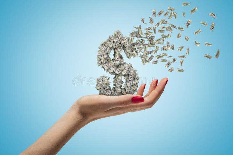 Female hand holding money dollar sign shattering on blue background. Money and finance. Banking and financial industry. Management and savings. Female hand holding money dollar sign shattering on blue background. Money and finance. Banking and financial industry. Management and savings.