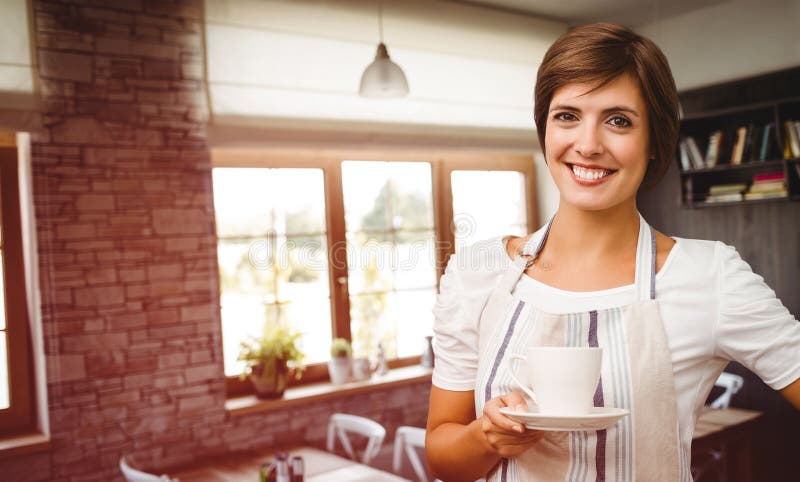 Smiling waitress holding a cup of coffee against empty chairs and tables. Smiling waitress holding a cup of coffee against empty chairs and tables