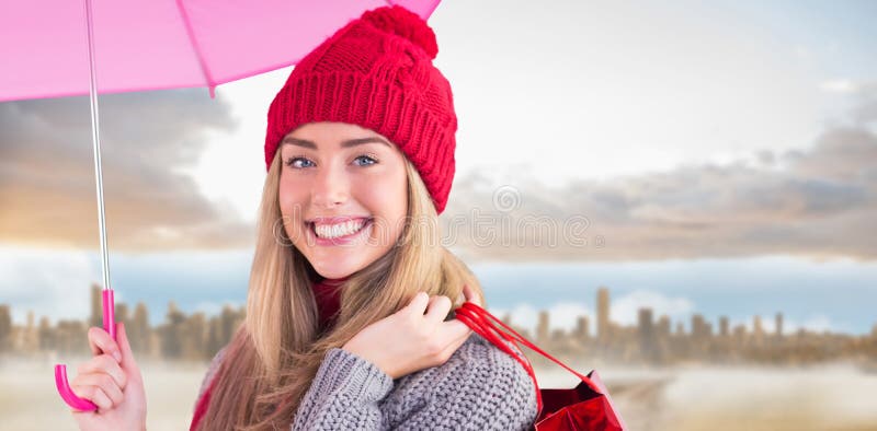 Sammansatt bild av det festliga blonda hållande paraplyet och påsar royaltyfria foton Sammansatt bild av det festliga blonda hållande paraplyet och påsar royaltyfria foton