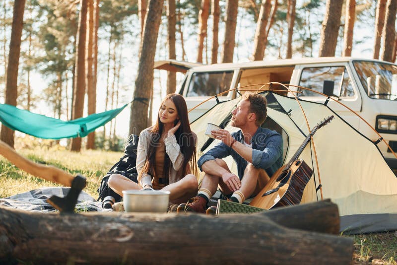 Sammansatt nära tältet. Unga par reser i skogen på dagtid tillsammans arkivbild