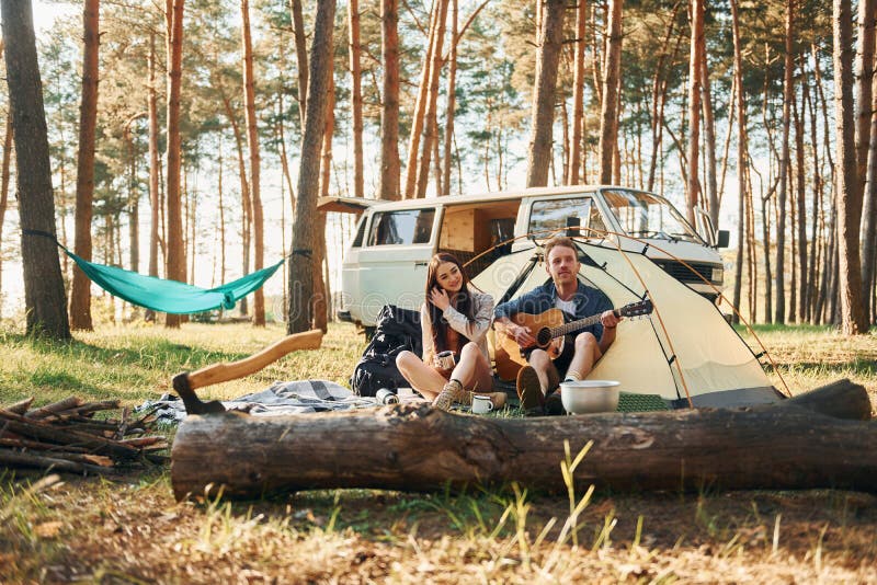 Sammansatt nära tältet. Unga par reser i skogen på dagtid tillsammans royaltyfri fotografi