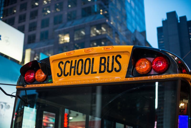 Sammanträde för transport för skolbussbarn bildande i parkeringen på natten i den New York City gatan royaltyfri foto Sammanträde för transport för skolbussbarn bildande i parkeringen på natten i den New York City gatan royaltyfri foto
