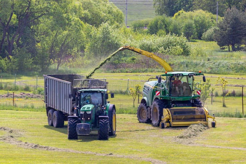 Kaplice, Czech republic - 06 02 2021: Self-Propelled forage harvester and tractor with silage trailer in the field. Kaplice, Czech republic - 06 02 2021: Self-Propelled forage harvester and tractor with silage trailer in the field