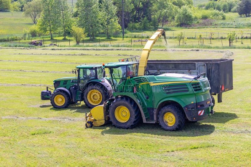 Kaplice, Czech republic - 06 02 2021: Self-Propelled forage harvester and tractor with silage trailer in the field. Kaplice, Czech republic - 06 02 2021: Self-Propelled forage harvester and tractor with silage trailer in the field