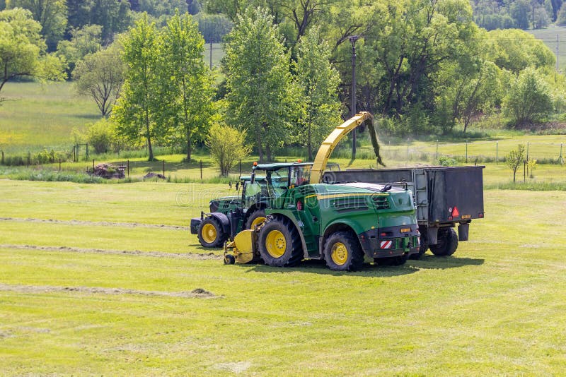 Kaplice, Czech republic - 06 02 2021: Self-Propelled forage harvester and tractor with silage trailer in the field. Kaplice, Czech republic - 06 02 2021: Self-Propelled forage harvester and tractor with silage trailer in the field