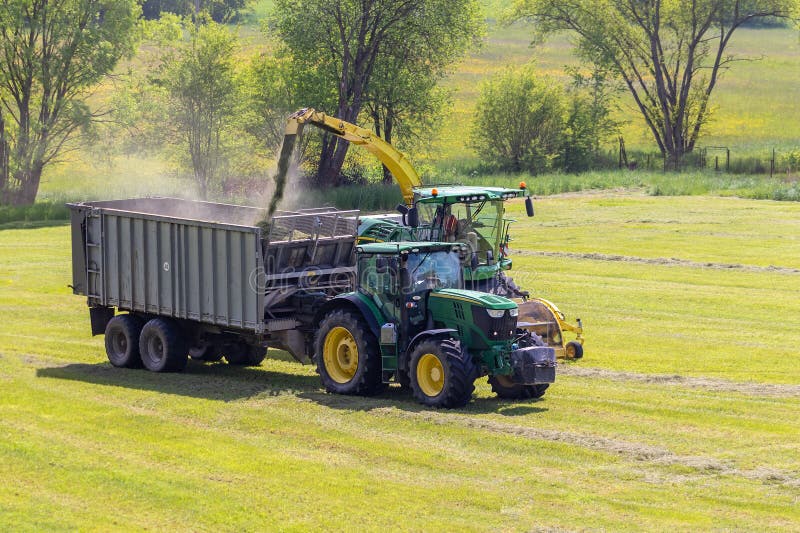 Kaplice, Czech republic - 06 02 2021: Self-Propelled forage harvester and tractor with silage trailer in the field. Kaplice, Czech republic - 06 02 2021: Self-Propelled forage harvester and tractor with silage trailer in the field