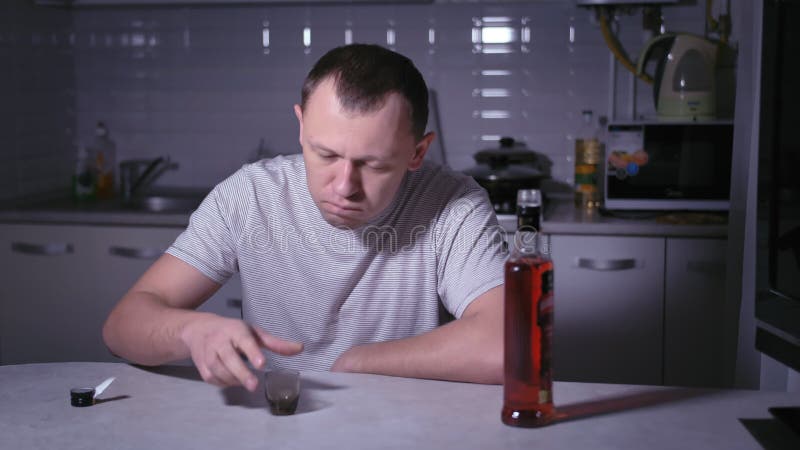 Samotny wieczór : pijany człowiek pijący samotnie w kuchni