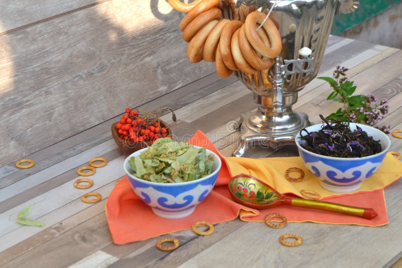 Samovar, en traditionell, gammal tekokare med bagels och örtte: lind, mynta och blomning sally royaltyfri fotografi