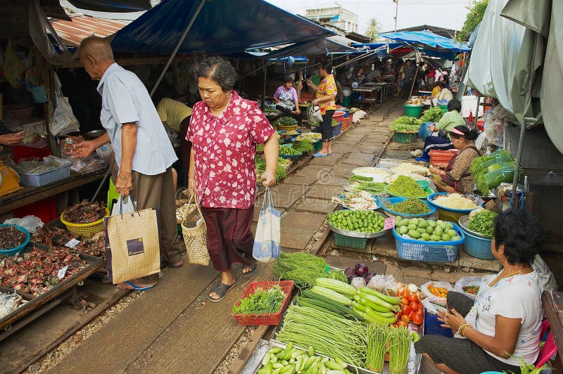 Local people do shopping at the Mae Klong railway tracks market in Samut Songkram, Thailand.