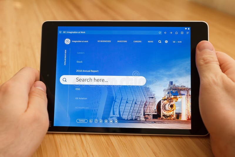 SAN FRANCISCO, de V.S. - 1 April 2019: Sluit tot handen houdend tablet gebruikend Internet en kijkend door GE-website, in San stock afbeelding SAN FRANCISCO, de V.S. - 1 April 2019: Sluit tot handen houdend tablet gebruikend Internet en kijkend door GE-website, in San stock afbeelding