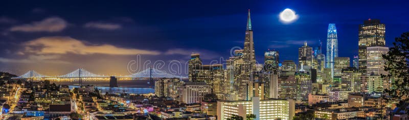 San Francisco downtown skyline sunset panorama with Bay Bridge and full moon between skyscrapers from Ina Coolbirth park