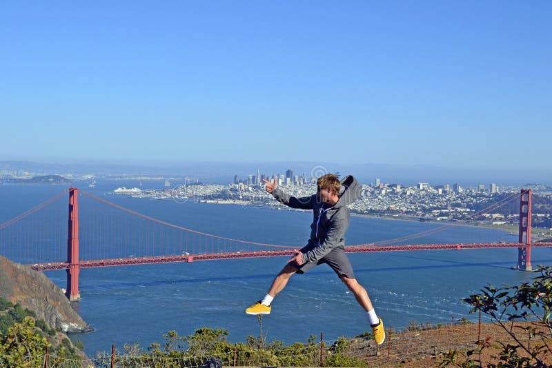 Giovane salto in alto di fronte al Golden Gate bridge a San Francisco.