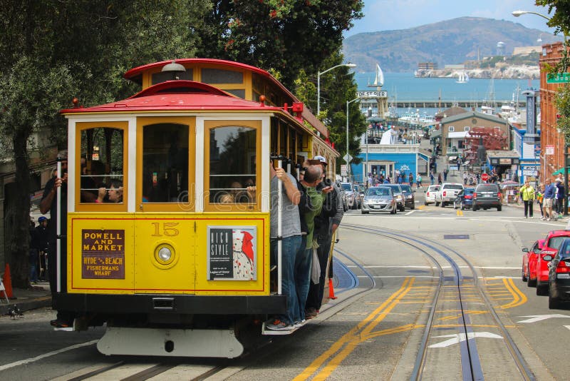 San Francisco Kalifornien - Mai 23, 2015: Turister som överst rider på den iconic kabelbilen, dag för blå himmel av den Hyde Stre fotografering för bildbyråer San Francisco Kalifornien - Mai 23, 2015: Turister som överst rider på den iconic kabelbilen, dag för blå himmel av den Hyde Stre fotografering för bildbyråer