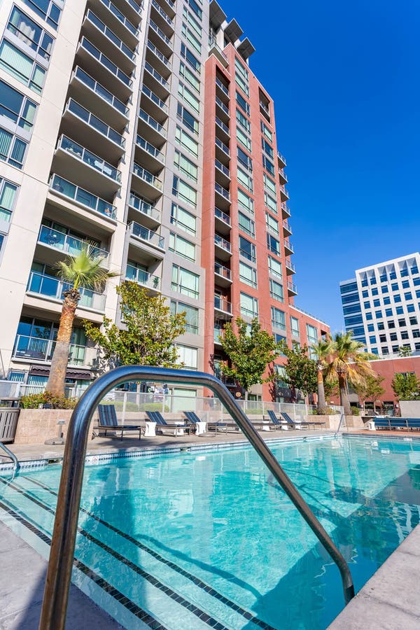 Oakland,California August 4,2023: swimming pool on a high-rise hotel with pool chairs,and a blue sky. Oakland,California August 4,2023: swimming pool on a high-rise hotel with pool chairs,and a blue sky