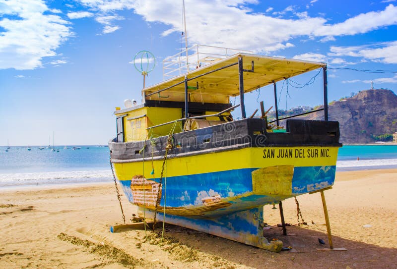 San Juan del Sur, Nicaragua - May 11, 2018: Outdoor view of yellow boat on the beach of San Juan Del sur on the ocean coast in Nicaragua with beautiful beache background in beautiful sunny day. San Juan del Sur, Nicaragua - May 11, 2018: Outdoor view of yellow boat on the beach of San Juan Del sur on the ocean coast in Nicaragua with beautiful beache background in beautiful sunny day.