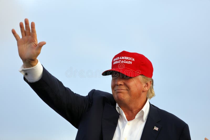 SAN PEDRO, CA - SEPTEMBER 15, 2015: Donald Trump, 2016 Republican presidential candidate, waves during a rally aboard the Battleship USS Iowa in San Pedro, Los Angeles, California while wearing a red baseball hat that says campaign slogan Make America Gre