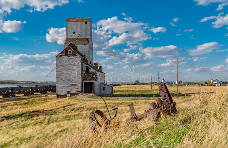 Sanctuary, SK/Canada- May 20, 2020:  Vintage steel wheels with historic grain elevator in Sanctuary